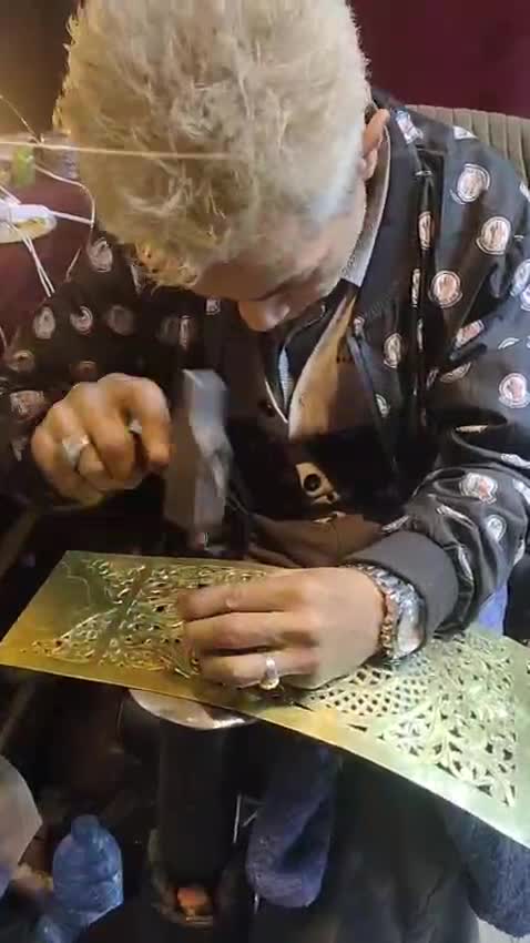 Artisan perforant à la main des motifs géométriques complexes